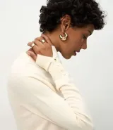 Suéter de punto ajustado con cuello redondo y manga larga. Presenta detalle de botones metalizados en los puños.