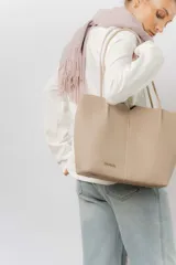 Cartera tipo tote de diseño amplio y estructurado, confeccionada en material sintético con textura graneada. Cuenta con doble asa larga para llevar al hombro y logo de la marca aplicado en el frente.