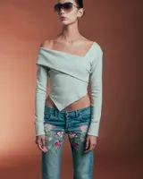 Top manga larga color gris claro, con escote asimétrico y corte irregular en el bajo.