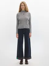 Polera gris de tejido suave al cuerpo, con cuello alto y mangas largas.