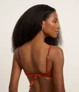 Top de bikini color ladrillo, de microfibra brillante, con breteles finos y adorno metálico en el centro del busto.