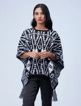 Poncho tejido con diseño tribal en blanco y negro, terminación con borlas.