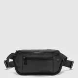 Riñonera compacta de color negro con diseño técnico, cierre principal y bolsillo frontal con cremallera. Incluye correa ajustable y detalle de marca en la parte inferior.