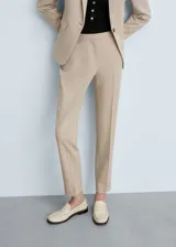 Pantalon de vestir de corte recto y tiro medio, color beige, con bolsillos laterales y bolsillos de ribete en la parte posterior.