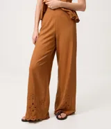 Pantalón pantacourt de Marfinno, color tostado, de corte amplio y cintura ancha. Con detalles de bordado calado tipo broderie y terminación ondulada en el bajo.