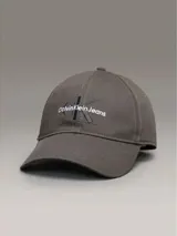 Gorra gris de algodón con visera curva y logo de Calvin Klein Jeans bordado en el frente. Ajuste trasero con hebilla metálica.