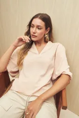 Blusa negra de silueta relajada con escote en V y mangas 3/4 con frunces en los hombros.