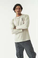 Remera de manga larga para hombre color beige, con cuello redondo y estampado en el frente. Confeccionada en algodón.