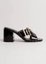 Sandalia de taco ancho color dorado, confeccionada en cuero vacuno, con diseño de tiras cruzadas y hebilla metálica decorativa.