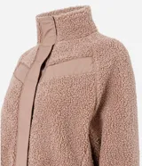 Campera bomber de mujer confeccionada en tejido sherpa color rosa viejo, con cuello alto, cierre frontal con cremallera y detalles de paneles lisos contrastantes en el pecho.