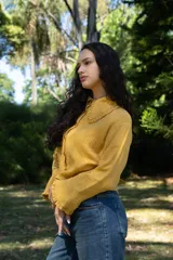 Camisa color mostaza de muselina, corte amplio, cuello con volados y botones frontales.