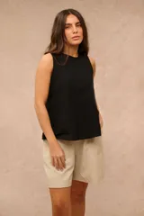Blusa sin mangas de color negro, corte suelto con costuras verticales decorativas en el frente.