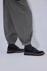 Pantalón tipo bombachita con pinzas que aportan volumen, confeccionado en Tencel. Presenta cierre frontal con botones dorados, bolsillos delanteros y ruedo ajustable mediante botón dorado.