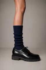 Zapato de cuero negro con cordones y suela chunky de goma con plataforma estriada.