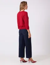 Cardigan de tejido fino en color gris, con cuello redondo, cierre frontal con botones y mangas tres cuartos.