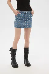 Minifalda de jean azul con tachas plateadas.