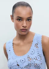 Top de crochet celeste con diseño floral, escote redondo y sin mangas.