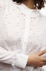 Camisa blanca de algodón con bordado floral, cuello redondo con volados y botones nacarados.