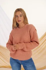 Sweater de punto color salmón, con cuello redondo y mangas largas.