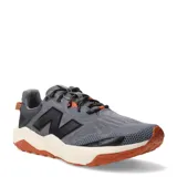 Championes de trail running New Balance modelo Dynasoft Nitrel V6, color gris con detalles en negro y naranja. Presentan una capellada de malla técnica transpirable, entresuela con tecnología Dynasoft para mayor amortiguación y suela de goma con relieve para un agarre superior en terrenos irregulares.