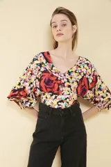 Top corto de viscosa con estampado floral, escote en V, mangas 3/4 con puños elastizados y ruedo trasero elastizado.
