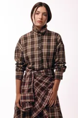 Camisa de corte recto y mangas largas con estampado de cuadros tartán en tonos marrones y beige. Presenta cuello camisero y cierre frontal con botones.