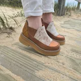 Zapatos de cuero estilo botineta baja en combinación de tonos marrones y beige, con suela chunky de plataforma plana y diseño texturizado en el talón.