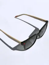 Lentes de sol negros con marco cuadrado y detalles rojos. Lentes con protección UV 400 y tecnología polarizada. Marca Osten, modelo Bali 2602.