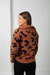 Buzo de tejido de punto con estampado animal print, cuello alto con cierre frontal y mangas largas.