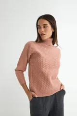 Polera de tejido de punto con cuello alto y textura acanalada en zigzag. Presenta mangas largas y puños ajustados, con un diseño clásico y versátil.