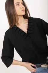 Blusa marrón de lino y viscosa con escote en V y cuello adornado con volados plisados, mangas tres cuartos y corte recto.