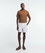 Bermuda de baño masculina color crema, confeccionada en microfibra, con trabillas en la cintura, cierre por botón, bolsillos laterales y traseros.