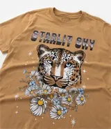 Remera alargada de algodón color ocre, con cuello redondo y mangas cortas. Presenta un estampado de la cara de un leopardo rodeada de flores y la frase "Starlit Sky".