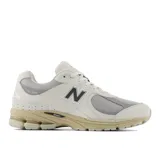 Championes urbanos New Balance modelo 2002R, color beige con detalles en gris y suela en tono arena. Confeccionados en una combinación de gamuza y malla, presentan el logo N característico en los laterales y tecnología de amortiguación en la entresuela.