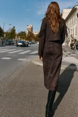 Chaqueta corta de Zara confeccionada en tejido efecto ante color marrón oscuro. Presenta cuello con solapas de muesca, manga larga y detalle de flecos en el mismo tejido a lo largo del pecho y la espalda. Cierre frontal cruzado con botones ocultos.