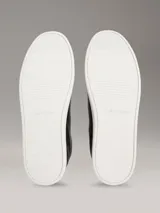 Zapatillas urbanas Calvin Klein de perfil bajo, color negro con suela blanca y detalle beige en el talón. Confeccionadas en cuero granulado, cuentan con cordones negros y el monograma de la marca grabado en el lateral.