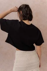 Remera crop color beige, de calce amplio, escote redondo y mangas cortas sueltas.