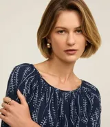 Blusa azul marino con estampa de ramos en color blanco, escote canoa, mangas largas con elástico en los puños y corte holgado.