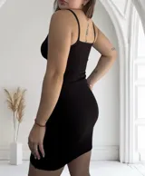 Vestido corto negro de breteles finos y corte ajustado.