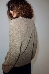Jersey de punto con hilo metalizado, cuello redondo y manga larga, de diseño clásico y acabado texturizado.