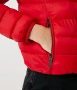 Campera puffer roja, ligera, de poliamida, con capucha y bolsillos con cremallera. Incluye bolsa para guardarla.
