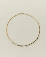 Gargantilla de cadena tipo omega en color dorado, con detalles de estrellas de acrílico transparente distribuidas a lo largo de la pieza.