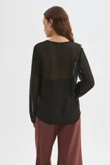Blusa blanca de poliéster con cuello en V, volados frontales y mangas largas con elástico en los puños.