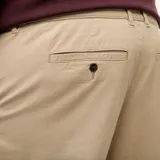 Pantalón chino de corte recto y diseño clásico, confeccionado en algodón elástico de color beige.