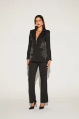 Blazer negro con solapas de muesca, cierre frontal con un botón y bolsillos delanteros con solapa. Presenta bordados florales en el frente.