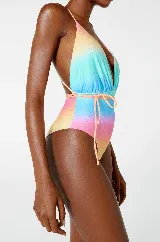 Traje de baño enterizo con estampado degradado en tonos celeste, amarillo, rosa y naranja. Tiene escote en V profundo, breteles finos y lazo ajustable en la cintura.