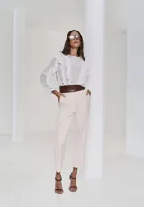 Camisa de color off-white con volados frontales, mangas largas con puños ajustados y diseño fluido de estilo romántico.