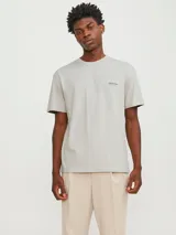 Remera de manga corta color gris claro, de corte relaxed y cuello redondo, con pequeño estampado tipográfico en el pecho.