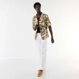 Pantalón de lino blanco de corte recto con cintura elástica y cordón ajustable.