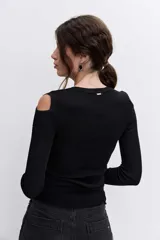 Blusa de punto acanalado color negro, con diseño de hombros descubiertos y manga larga.